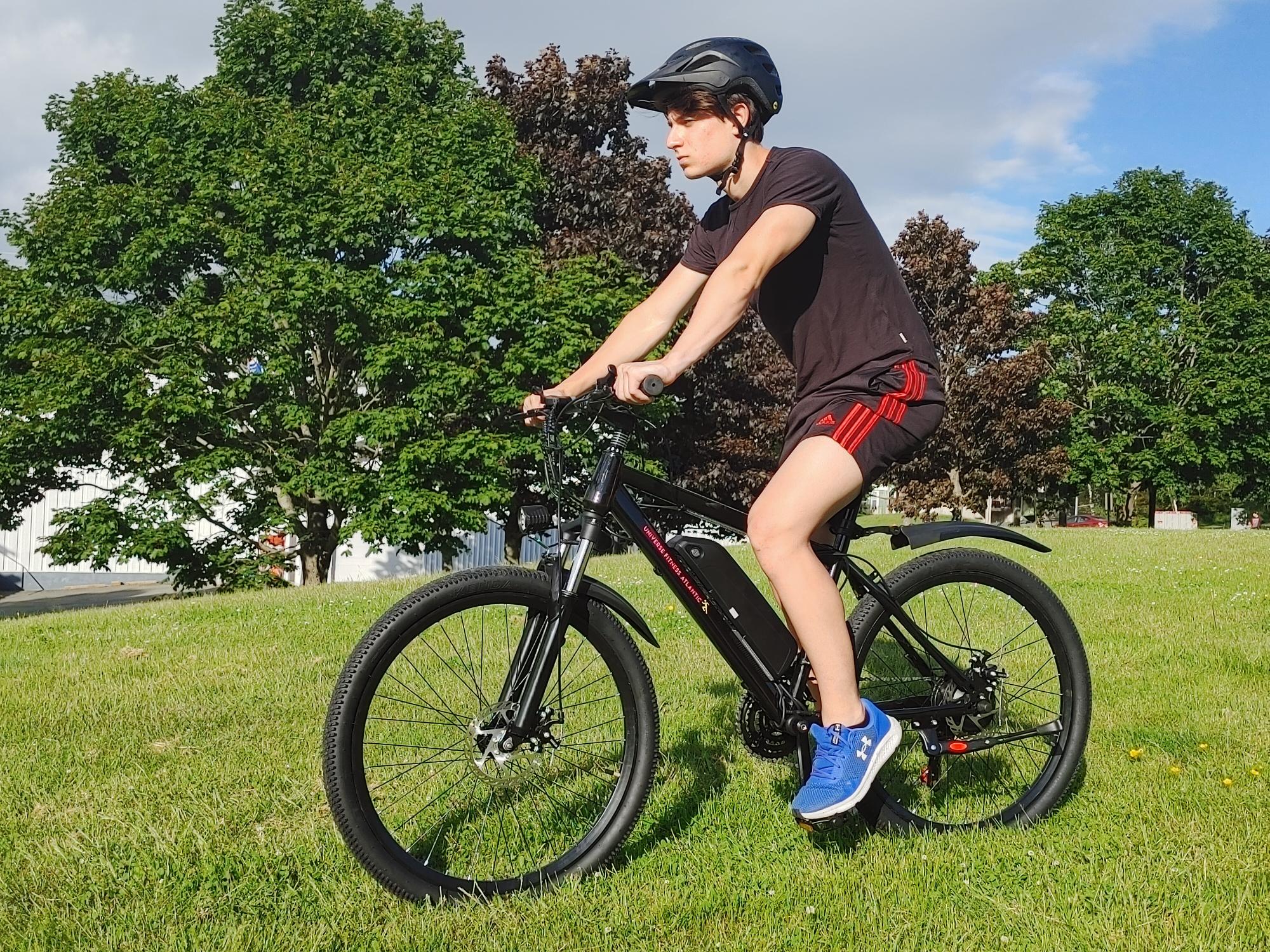 Black electric bike with rider, Capital Bikes Ottawa Gatineau